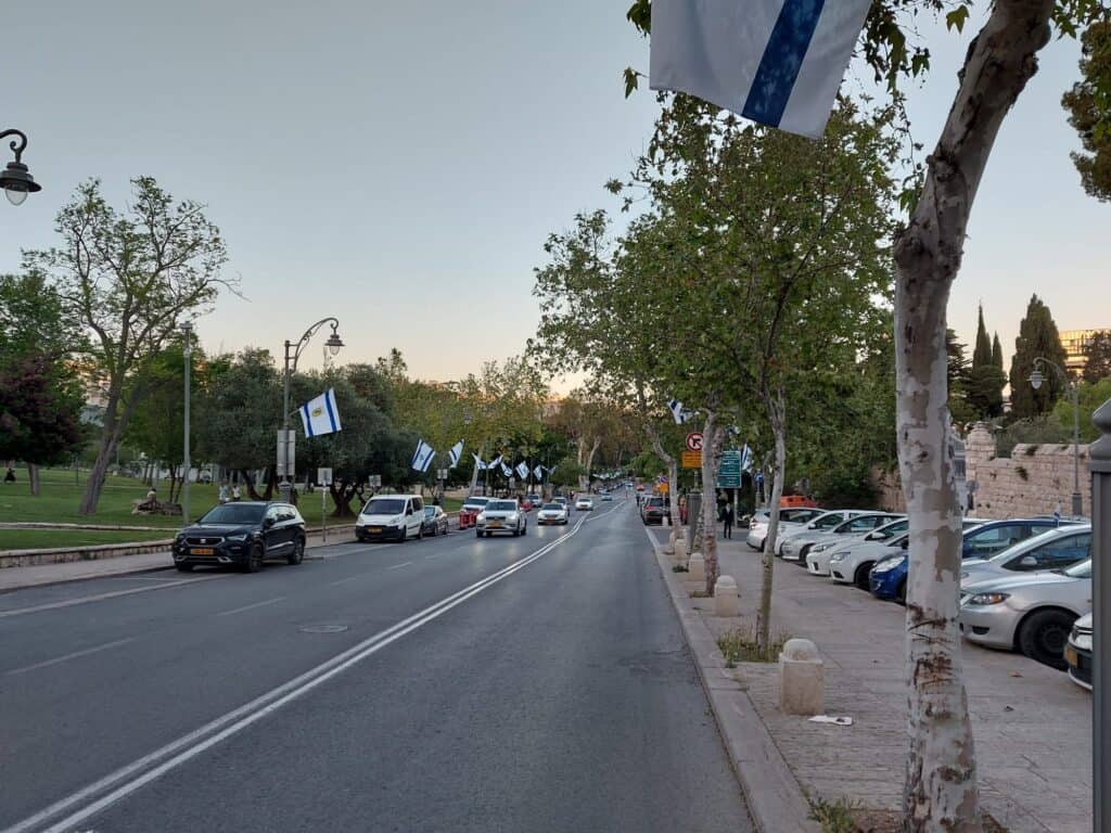 שורת רכבים חונים לאורך רחוב מרכזי בירושלים