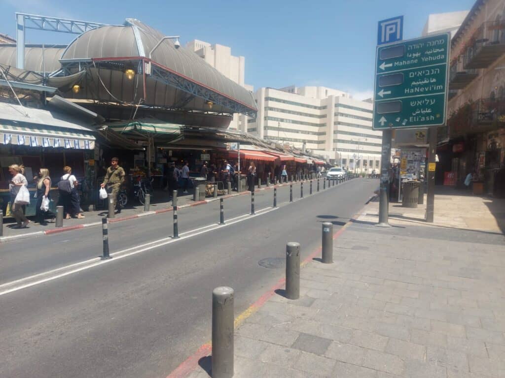 שוק מחנה יהודה בירושלים, רחוב כמעט ריק עם שלט הכוונה בעברית, ערבית ואנגלית