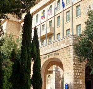 חזית מלון המלך דוד בירושלים, אייקון היסטורי ונקודת מפגש עולמית. מבנה המלון והדגלים בחזיתו, המייצגים היסטוריה חיה בעיר.