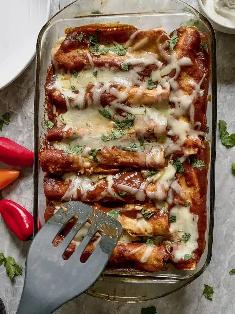 red homemade gluten free chicken enchiladas being dished up with spatula