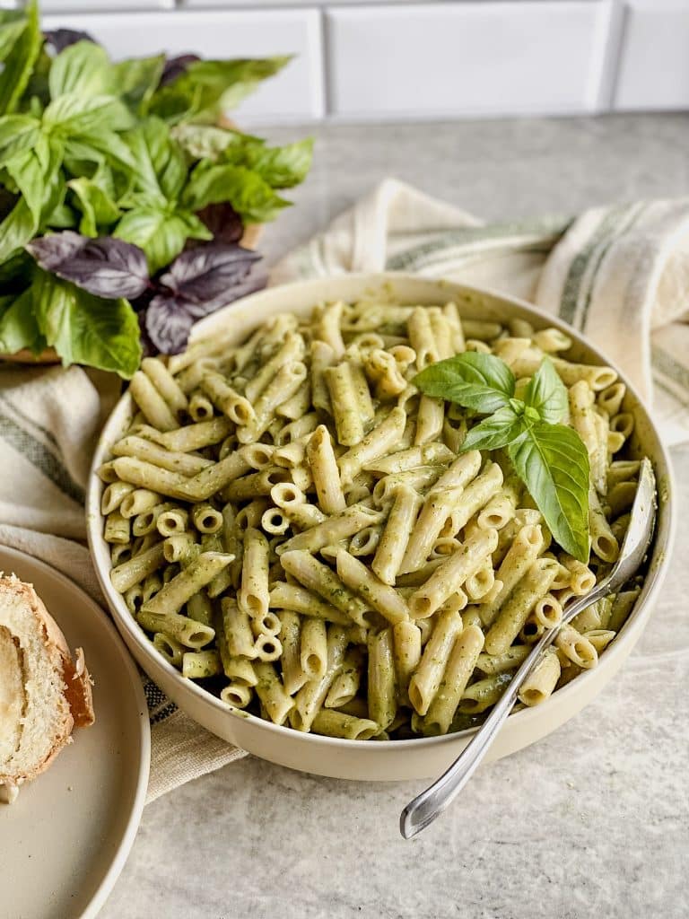 bowl of penne noodles with gluten free dairy free creamy pesto sauce