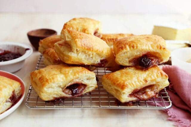 Baked brie in puff pastry on cooling rack.