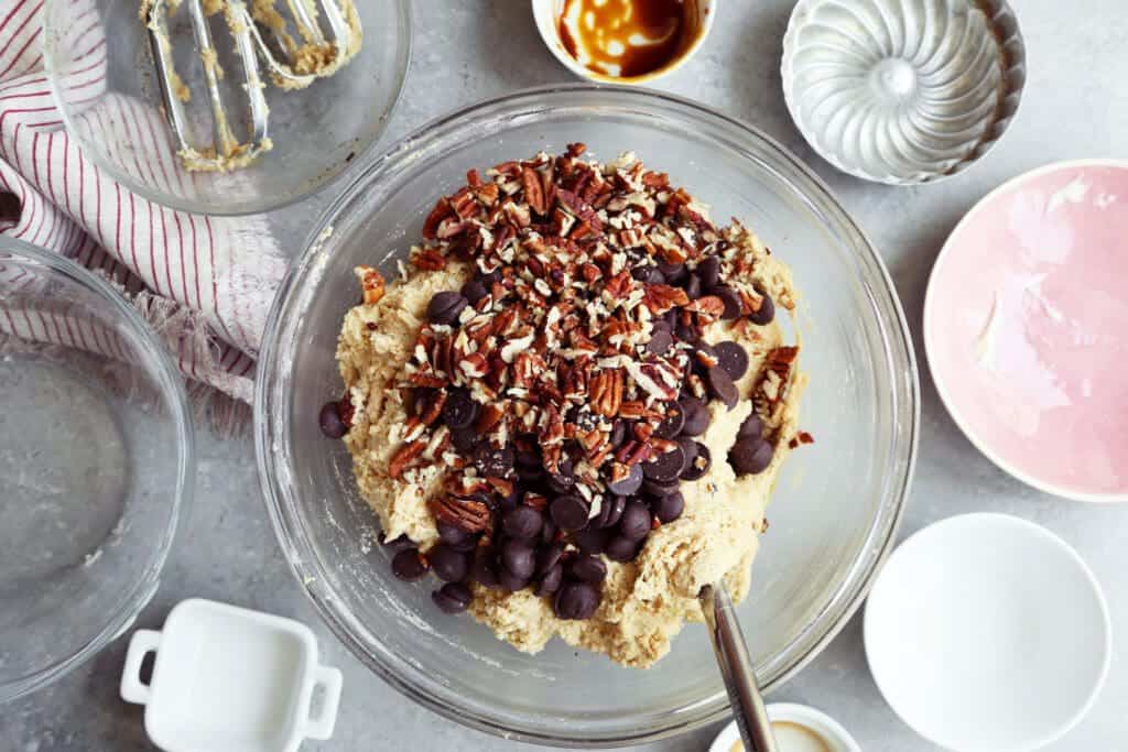 Pecans and chocolate chips to cookie dough.