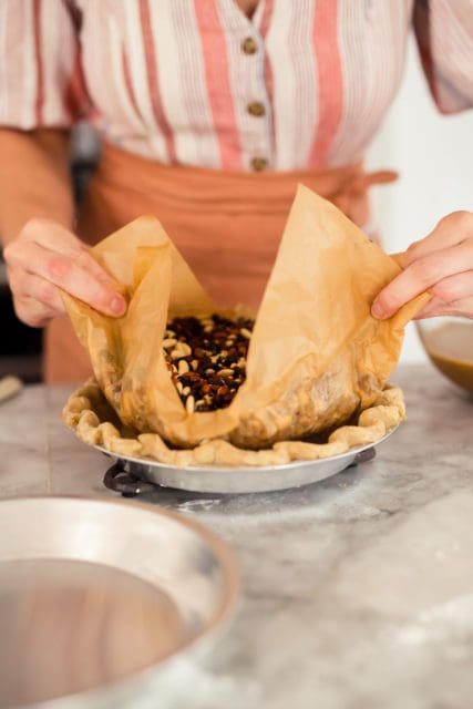 Removing dried beans from the par-baked crust.