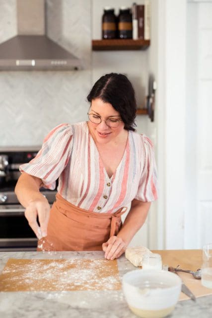 Joy the Baker dusting a piece of parchment paper with flour.