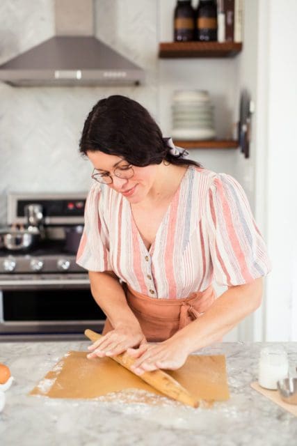 Joy the Baker rolling out pie crust between two pieces of parchment paper.