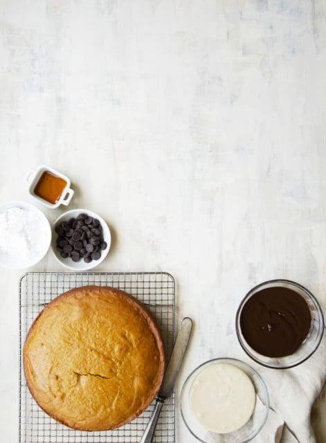 Easy pumpkin cake recipe cooling on a wire rack with glaze in small bowls.