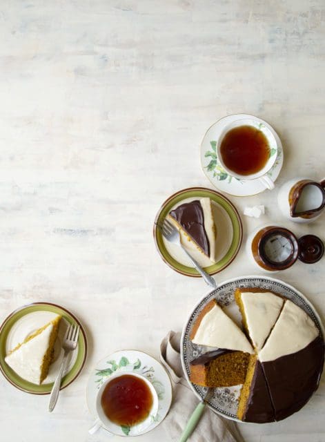 Sliced pumpkin cake on small plates with tea.