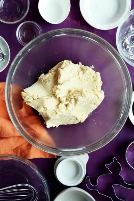 Halloween sugar cookie dough in a clear bowl.