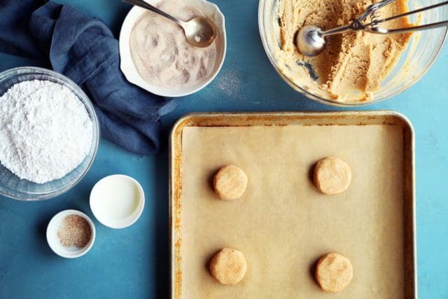 Dough ball portions on a parchment lined baking sheet to be baked