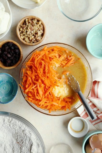 Shredded carrots and crushed pineapple added to carrot cake recipe wet ingredients.