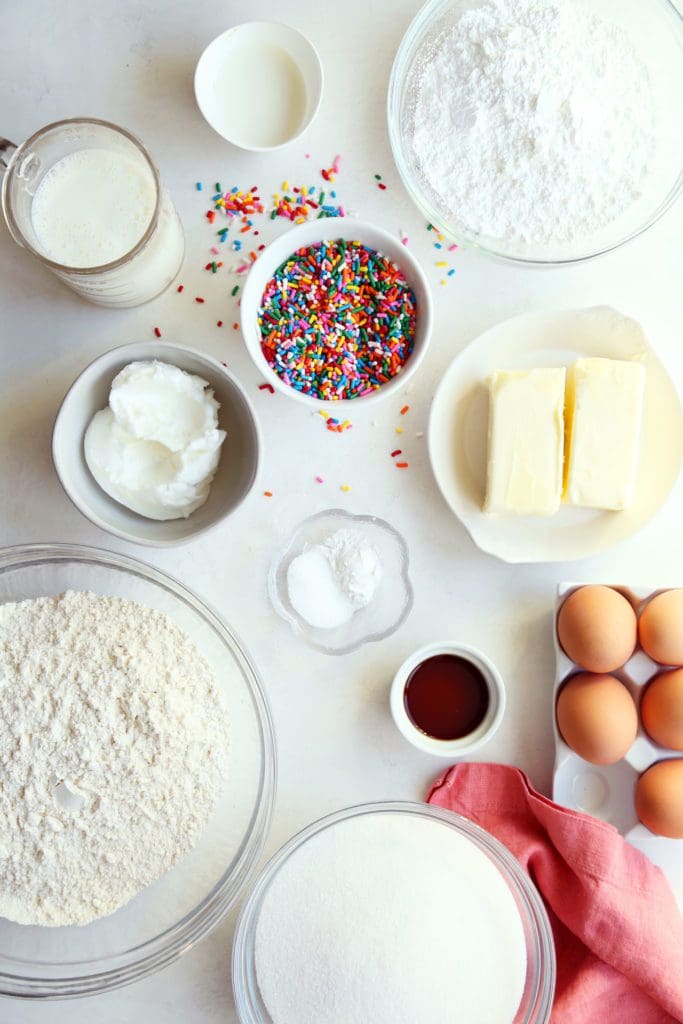Ingredients for funfetti cake recipe in small bowls.