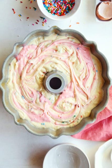 Funfetti cake batter swirled in bundt pan