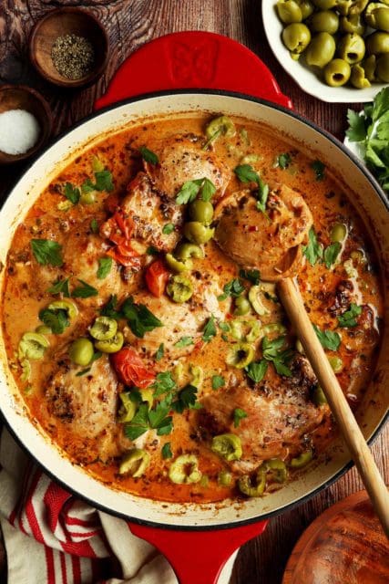 Baked Marry Me Chicken topped with green olives and fresh parsley.