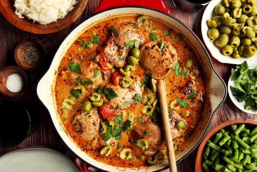Baked Marry Me Chicken topped with green olives and fresh parsley.
