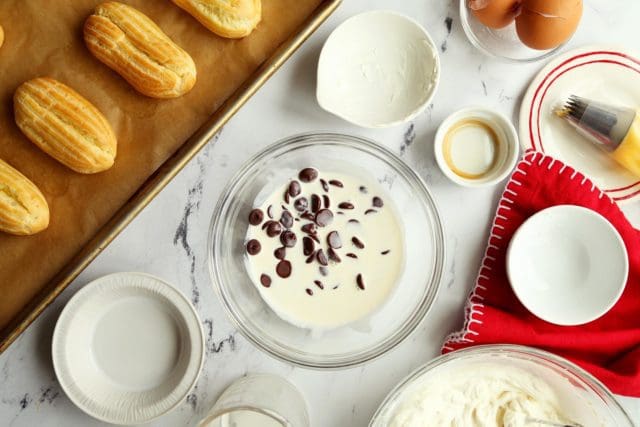 Hot cream and chocolate pieces in small bowl for chocolate ganache.