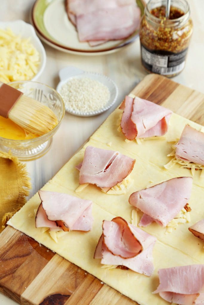 Ham folded over cheese and mustard on unbaked puff pastry