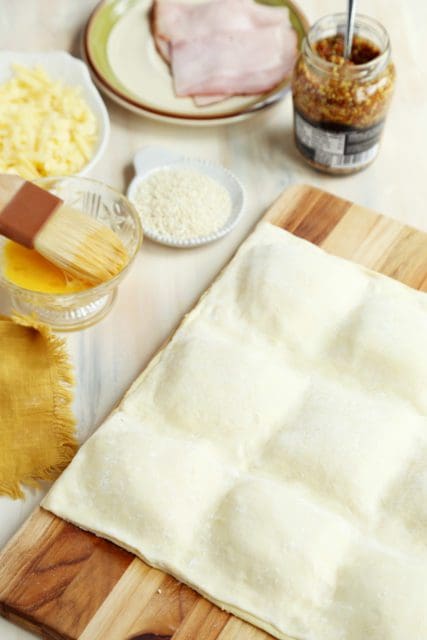 Top layer of unbaked puff pastry placed over ham, cheese and mustard