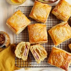 Baked croissants sliced in half on wire rack.