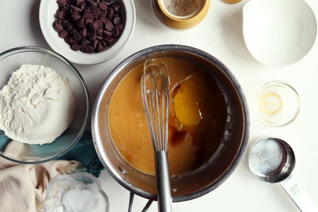 Adding egg and vanilla to sugar and butter.