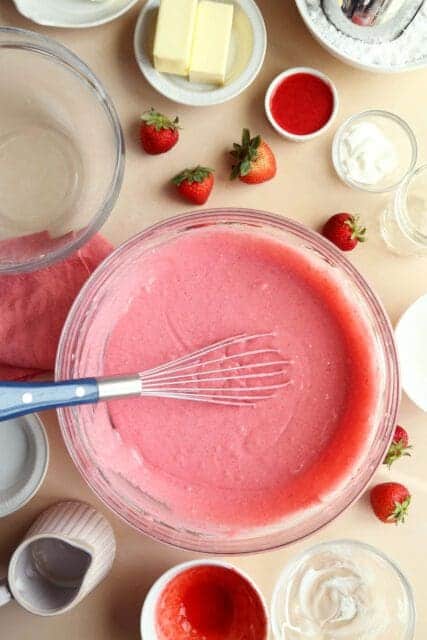 strawberry cake pink cake batter whisked in bowl.