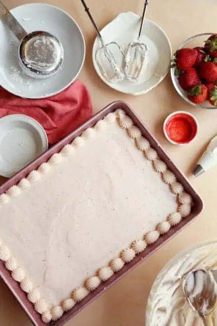 frosted strawberry cake in sheet pan.