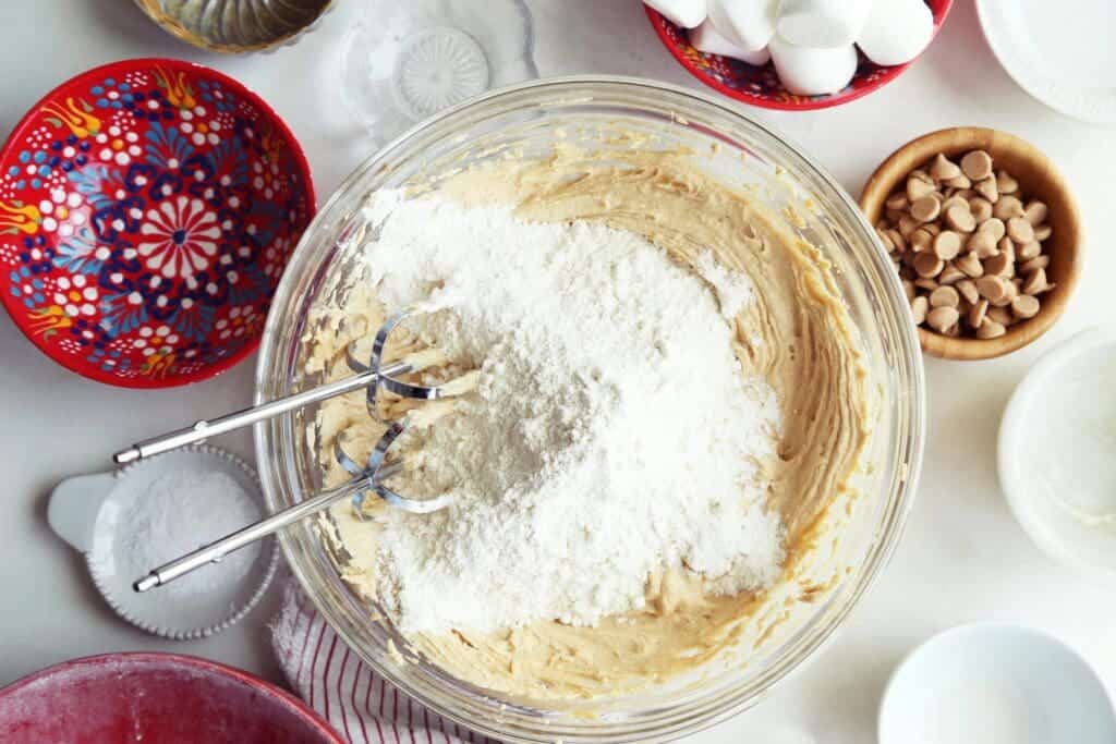 Dry ingredients added to cookie dough in medium bowl.
