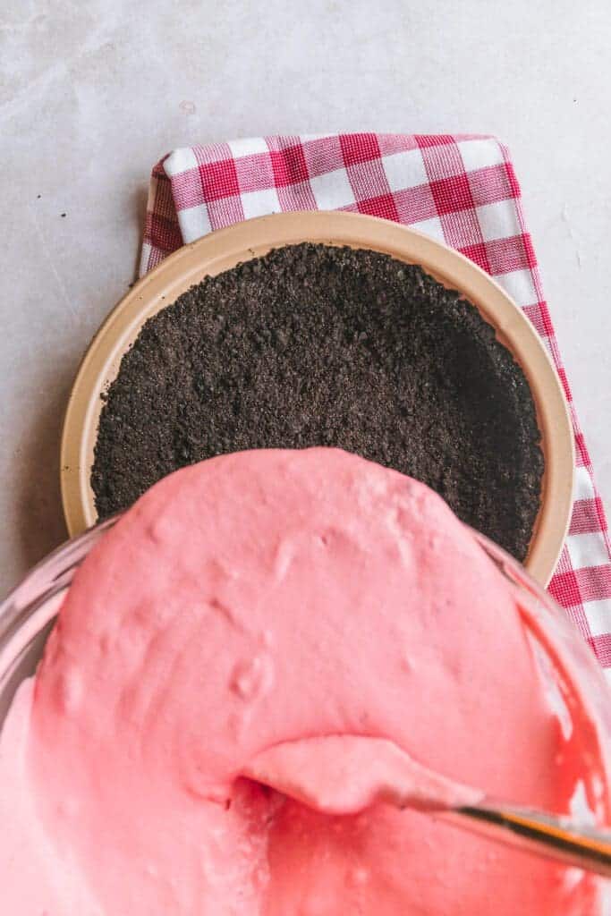 Pouring pie filling into chocolate crust.