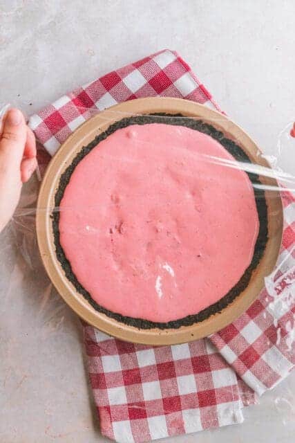 Covering pie filing with plastic wrap to refrigerate.