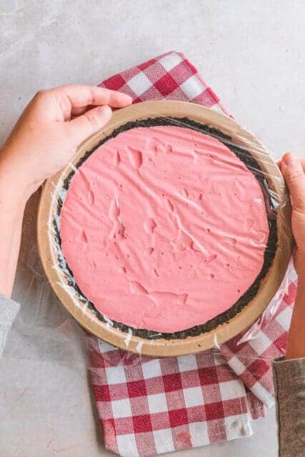 Covering pie filing with plastic wrap to refrigerate.