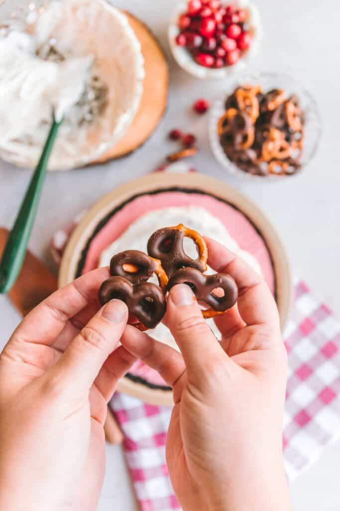 Holding chocolate covered pretzels.