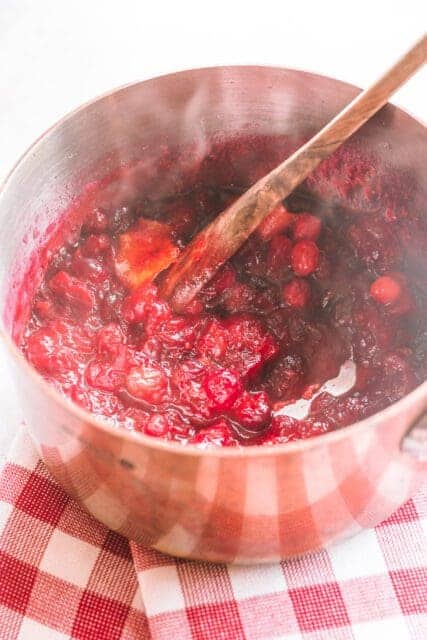 Fresh cranberry sauce cooked in a small saucepan