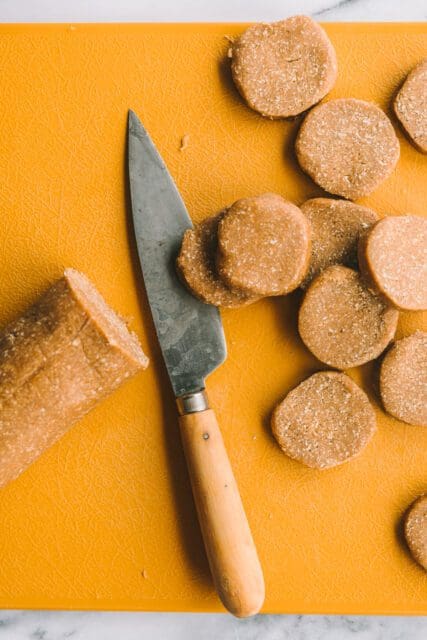 Slicing iced oatmeal cookie dough with vintage knife.