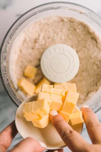 Adding butter to food processor for iced oatmeal cookies.