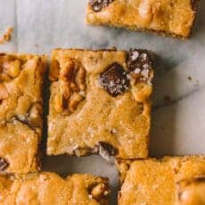 completed recipe close up shot of a blondie so the toasted almonds, chocolate chips, and sea salt can be seen