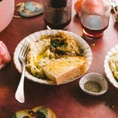 French onion chicken in a bowl surrounded by glasses on a table