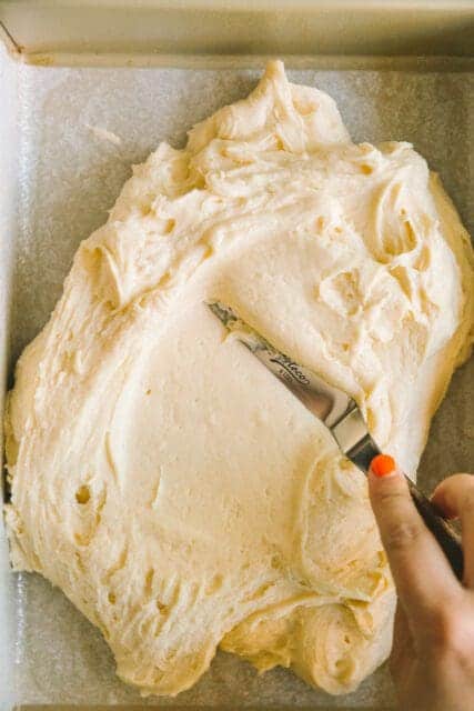 spreading 4th of July cake batter in a pan with an offset spatula