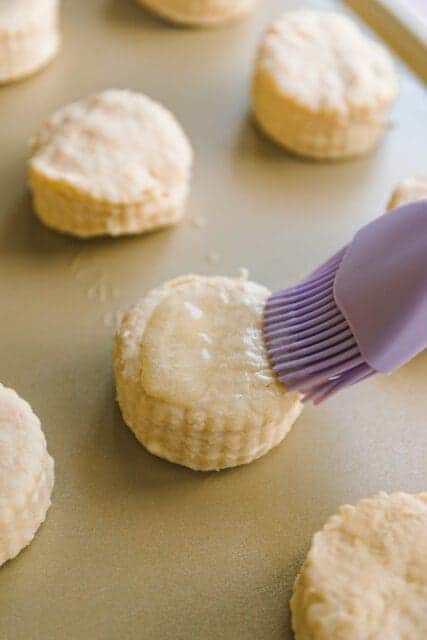 brushing melted butter onto shortcake rounds