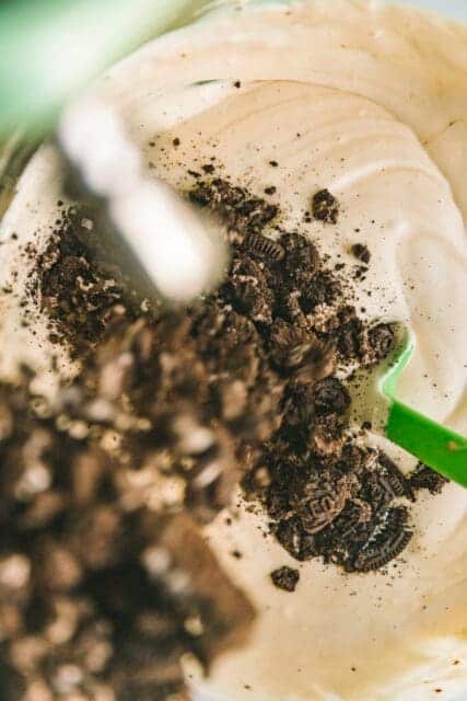 adding crushed cookies to soft cream mixture