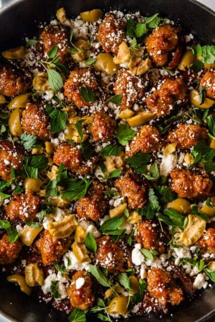 close up of stuffed dates in tomato sauce with cheese and fine herbs