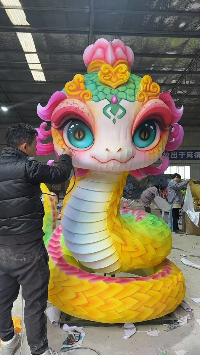 Worker is painting a snake lantern in the factory