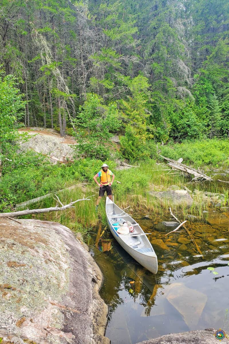man standing near a canoe in the Boundary Waters Canoe Area Wilderness