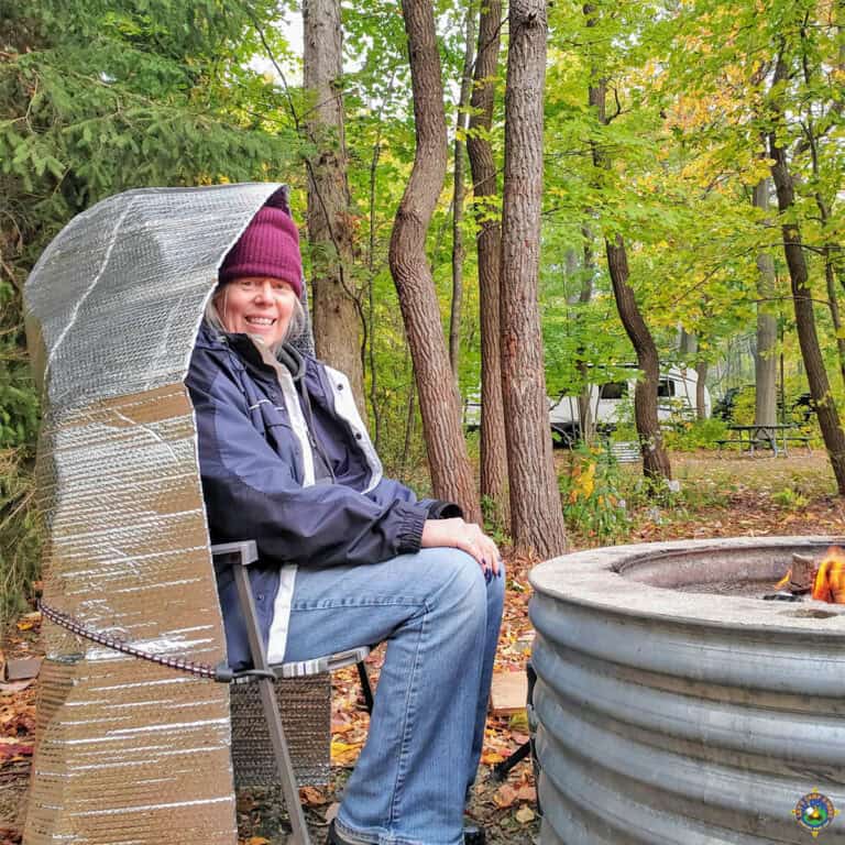 woman Keeping Warm by the Campfire with a Fire Reflector