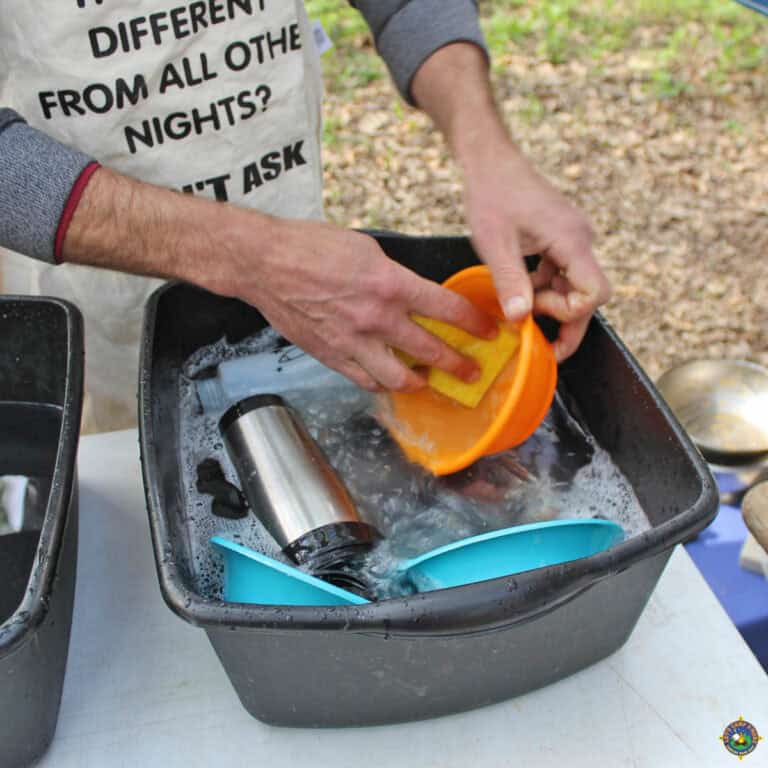 Man Washing Camping Dishes Outside
