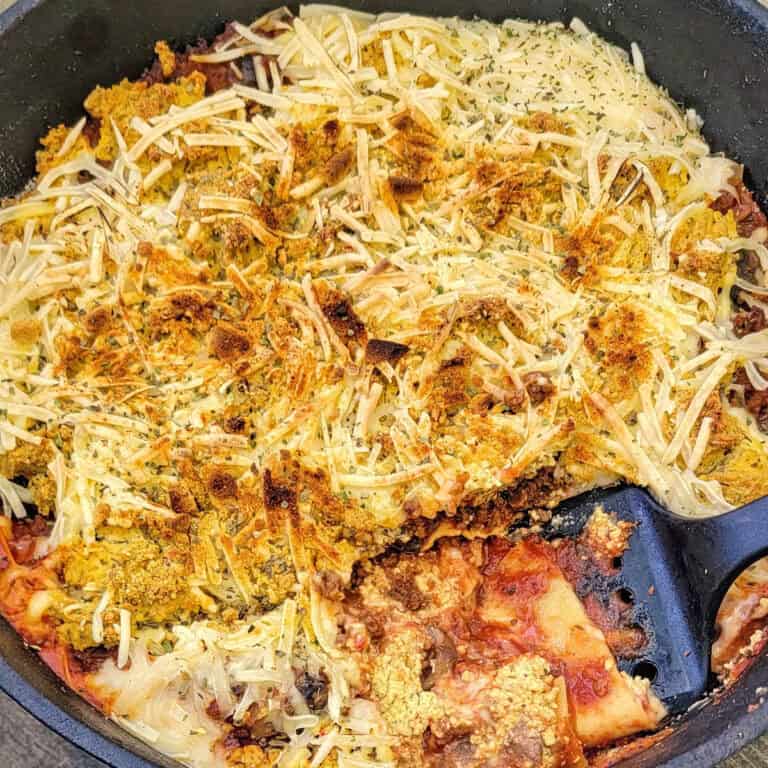 cast iron pot of lasagna being served