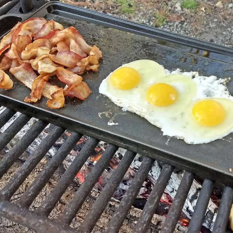 eggs and bacon on a griddle over the campfire
