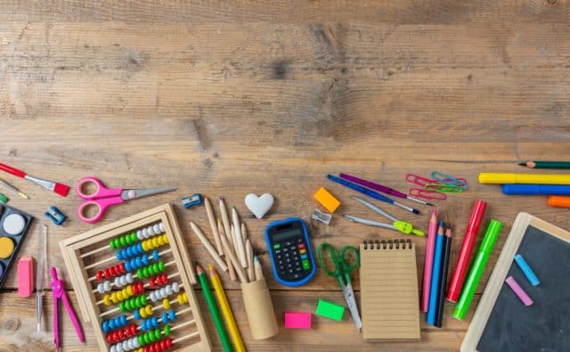 Back to school. School supplies on wooden background, top view