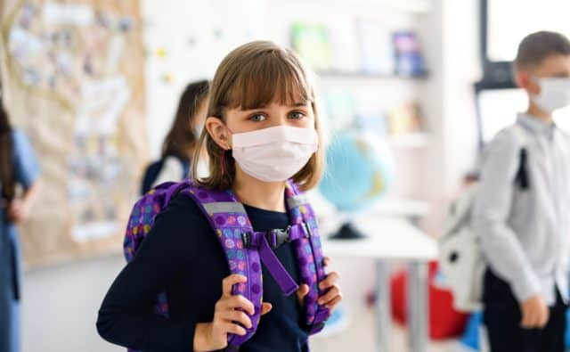 Child with face mask going back to school after covid-19 quarantine and lockdown