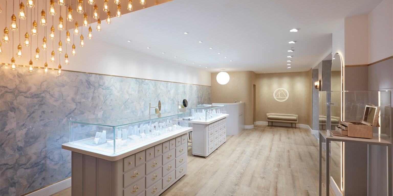 View of the store having two jewelry display cabinets on the left and a single glass cabinet with a box in it on the right.