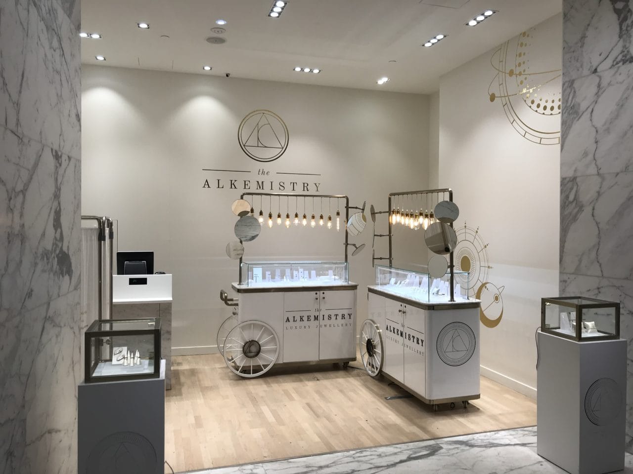 The Alkemistry store with various glass displays and marble patterned walls from the left angle.